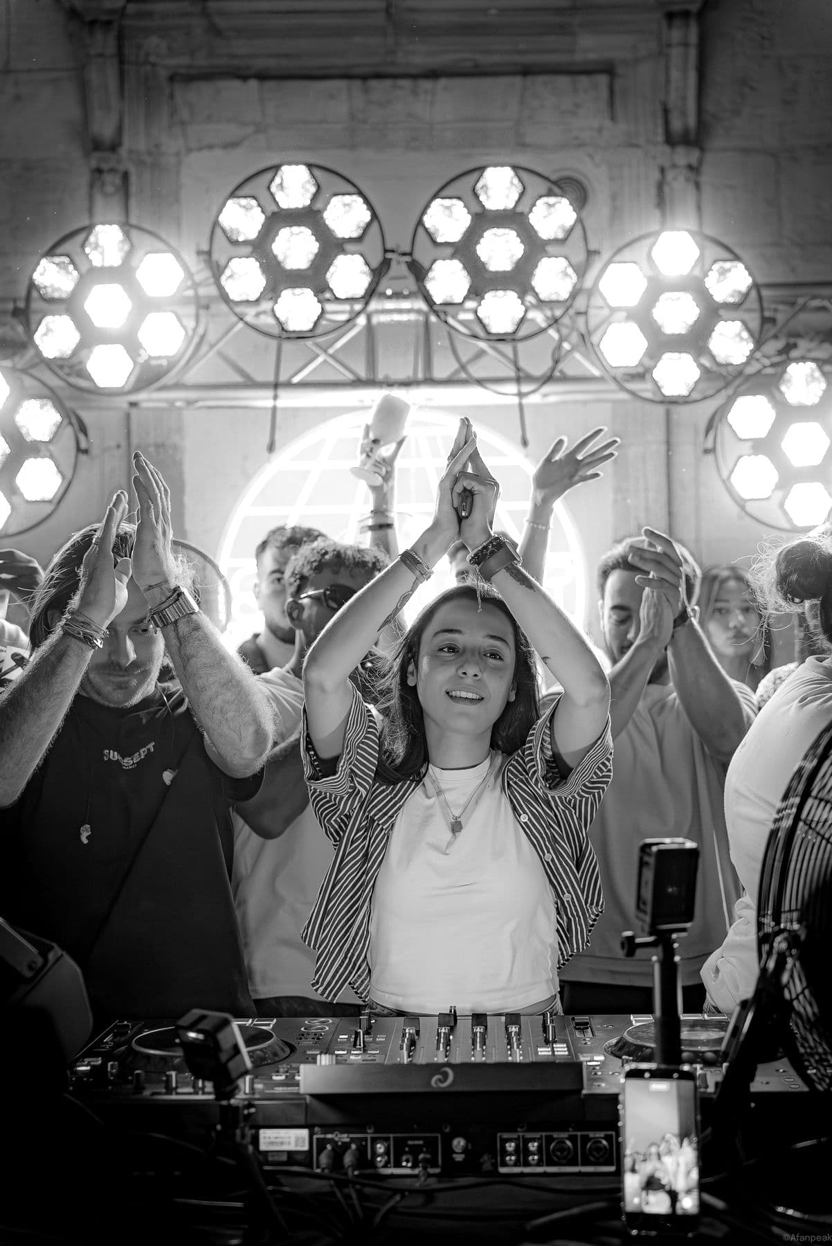 GUAPPA clapping above the decks in front of a crowd