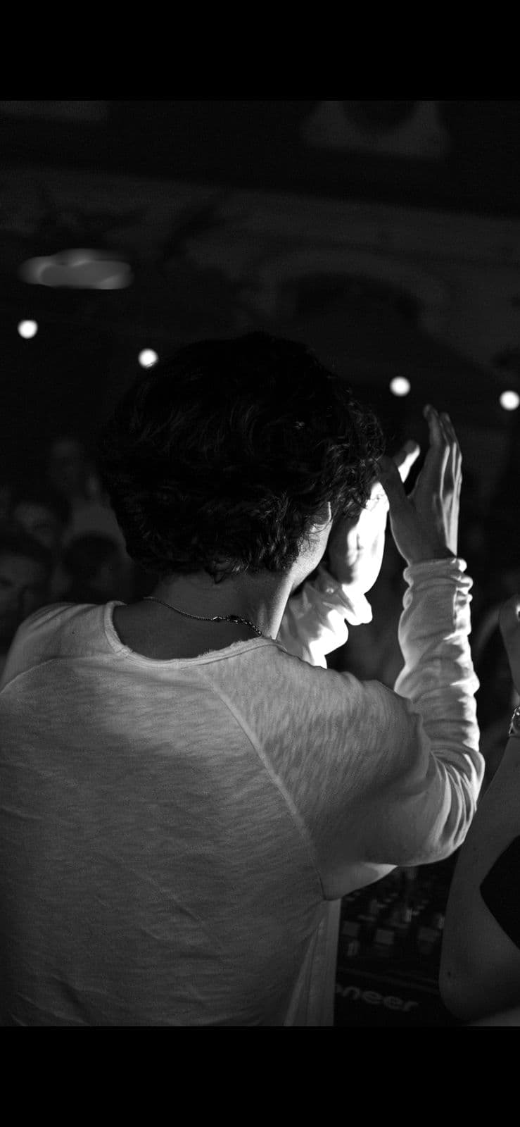 ONEYED performing behind the decks, seen from the crowd