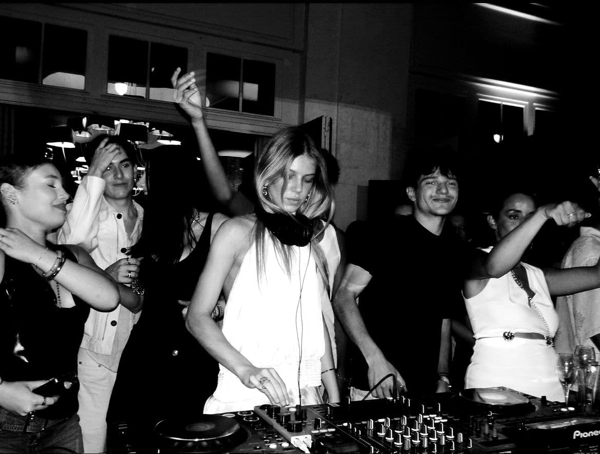 MYKANA behind the decks surrounded by dancers